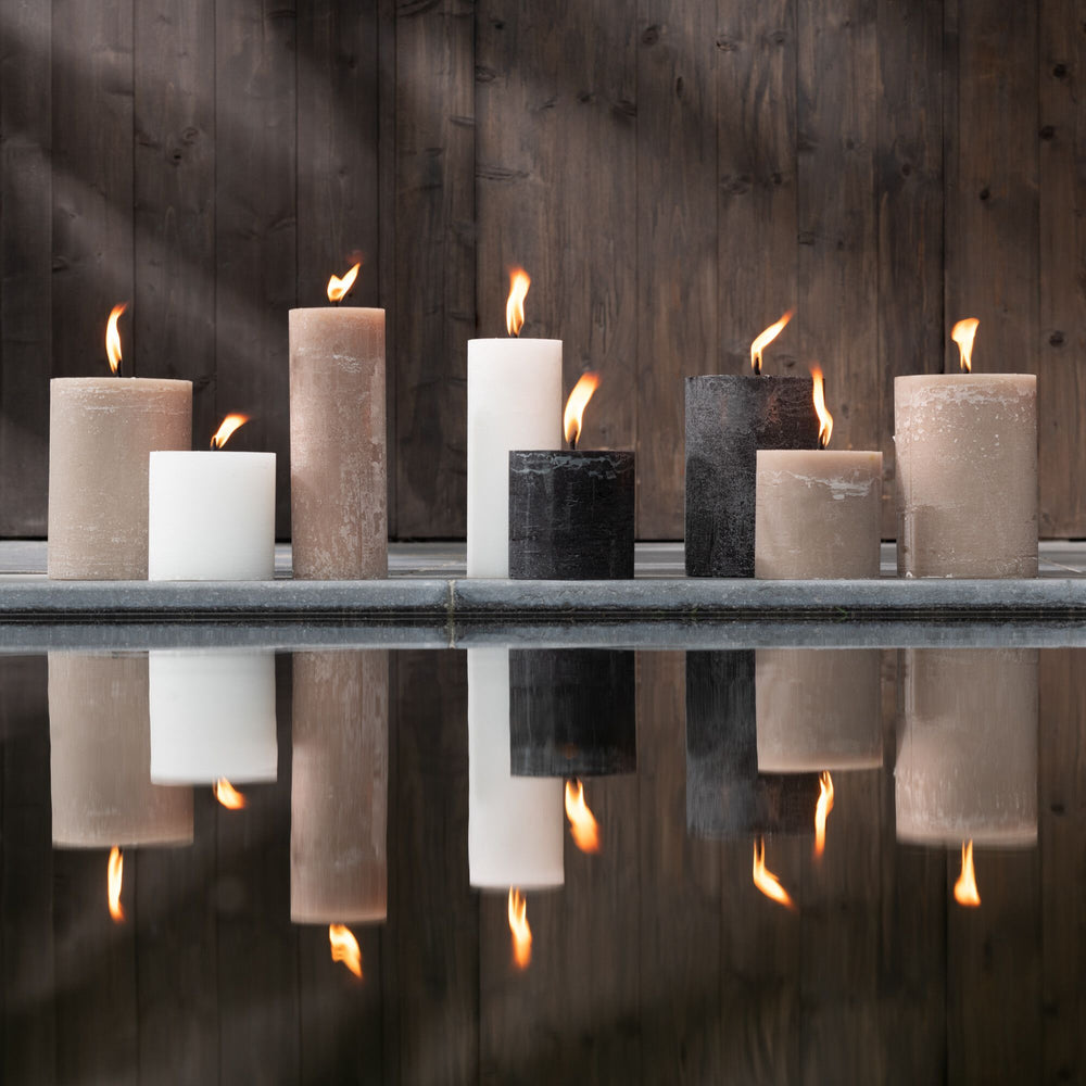 Lifestyle view of Mahe Brown Outdoor Candles displayed on a shelf with warm ambient lighting.