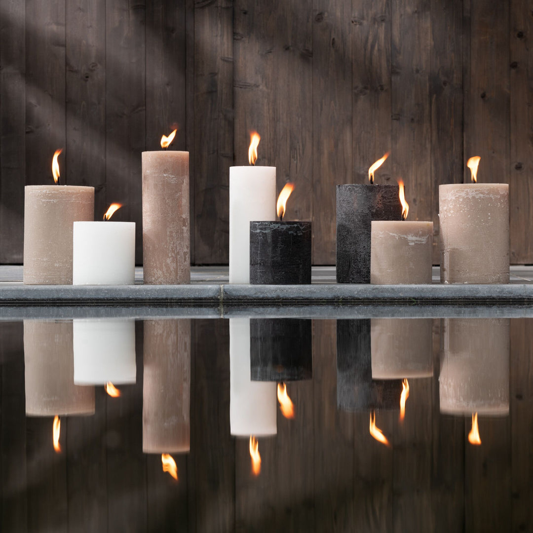 Lifestyle view of Mahe Brown Outdoor Candles displayed on a shelf with warm ambient lighting.