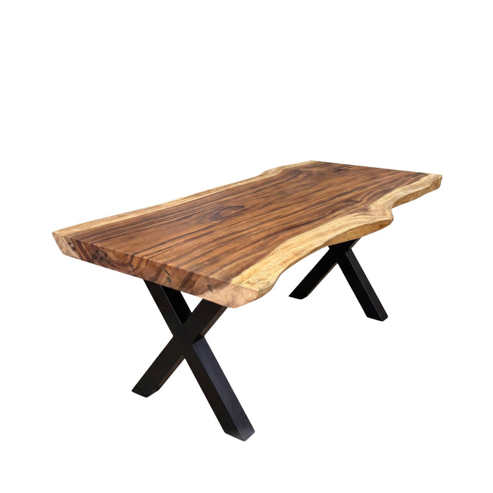 Front view of the Makai suar wood dining table showing its natural live-edge top and black metal X-shaped base.