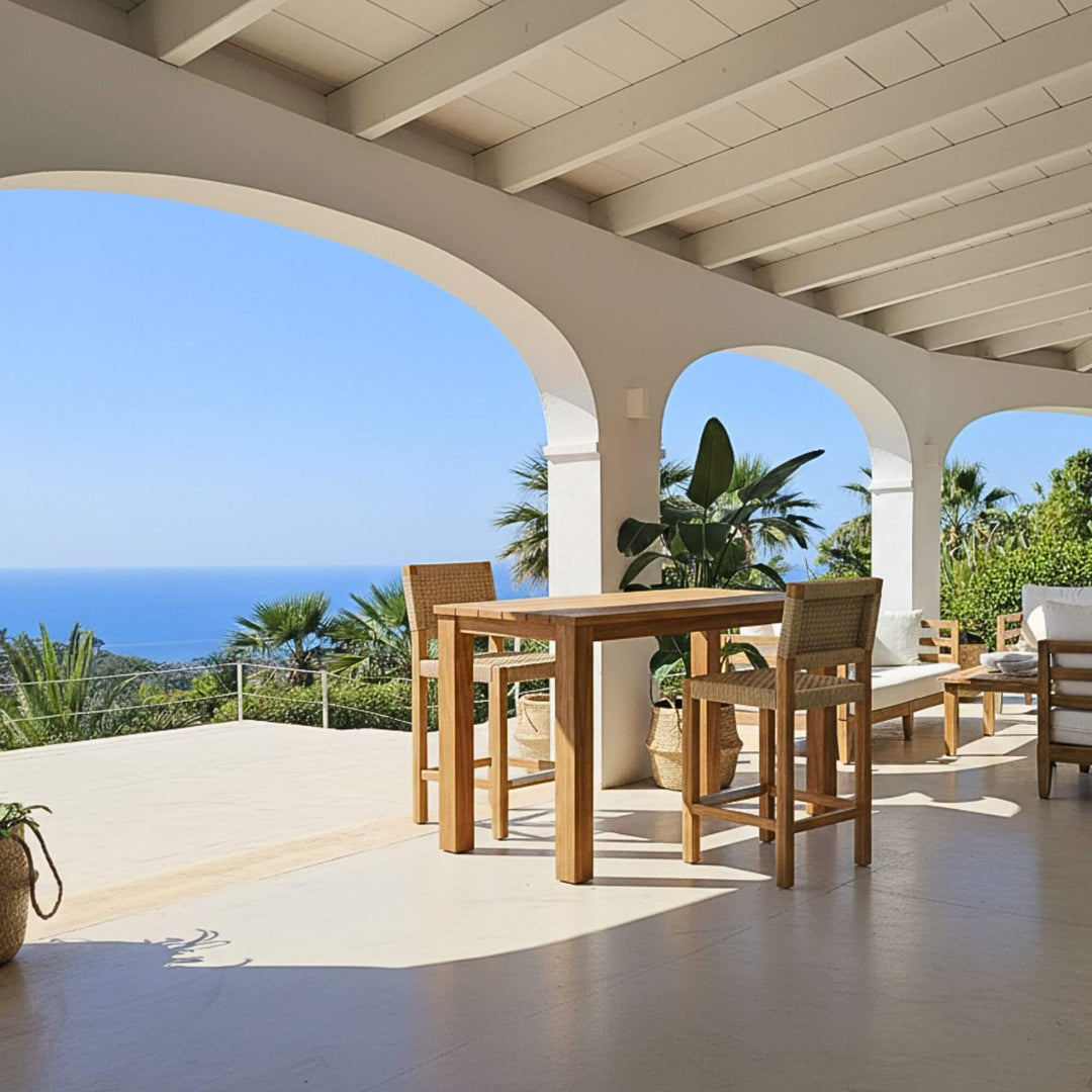 Outdoor terrace setting featuring the Maldives bar table under a covered pergola.