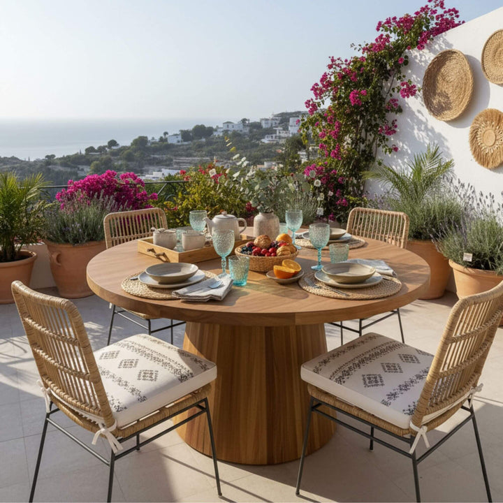 Outdoor dining setup featuring the Maldives round recycled teak table with conical base.