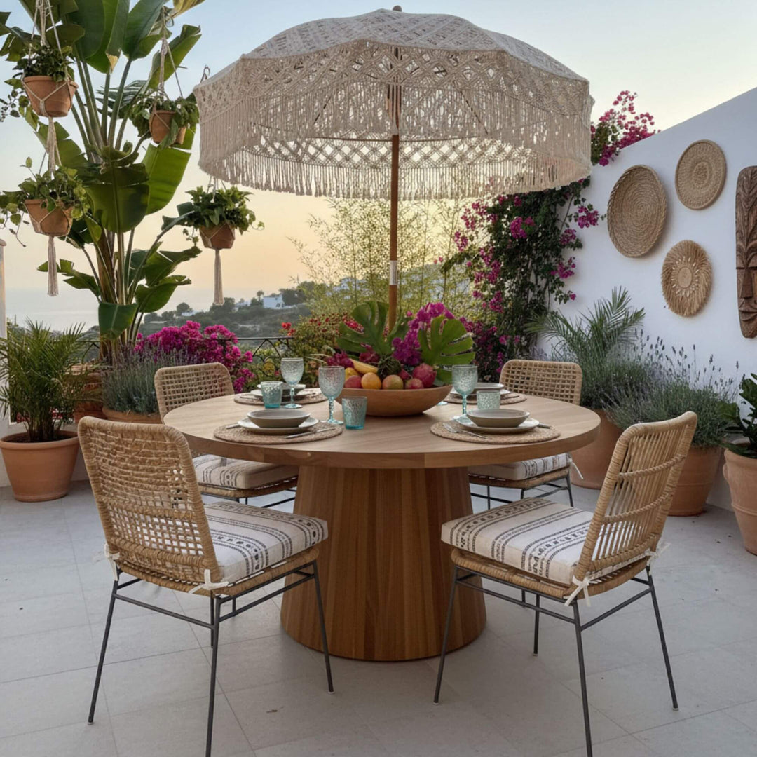 Terrace scene with the Maldives round teak dining table styled for al fresco meals.