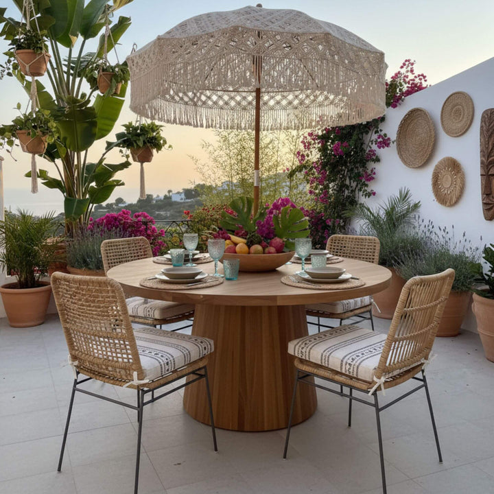 Terrace scene with the Maldives round teak dining table styled for al fresco meals.