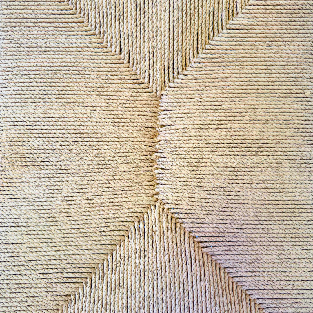 Seat close-up showing hand-woven paper-loom pattern and texture