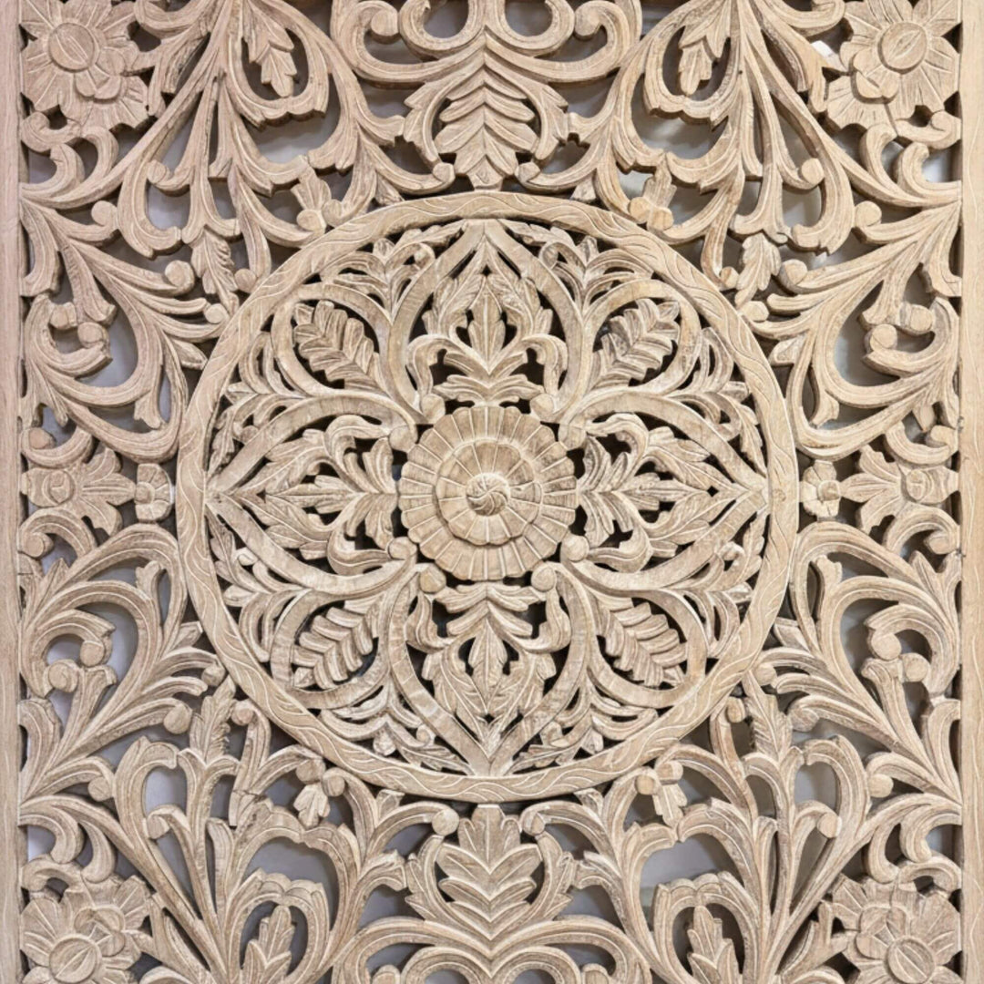 Close-up of the central mandala carving on the white-washed panel.