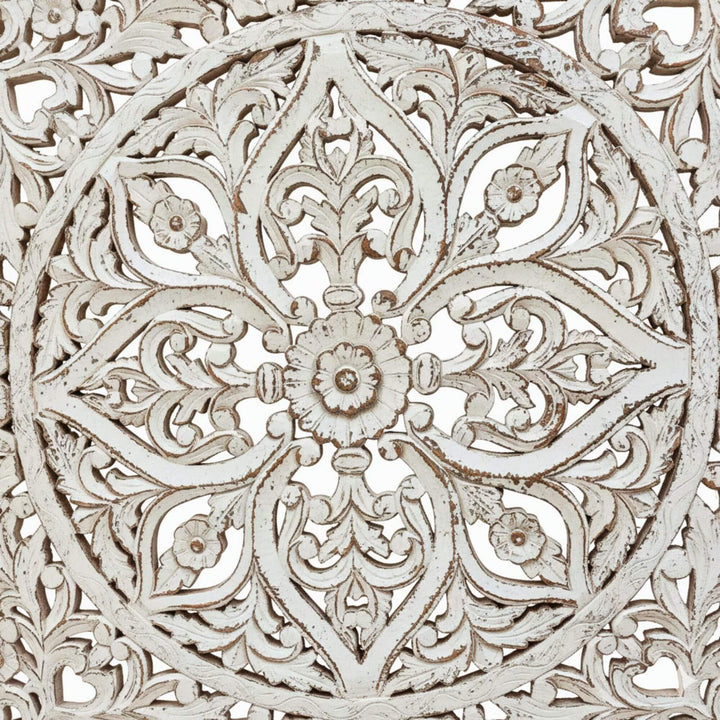 Close-up of the carved floral details on the white-wash mandala panel.