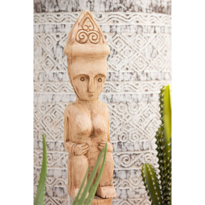 Close-up of the carved facial and body details on the Masira deco stand.