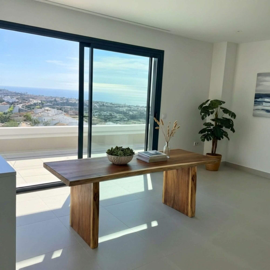 Suar wood dining table styled in a modern interior with ocean views.