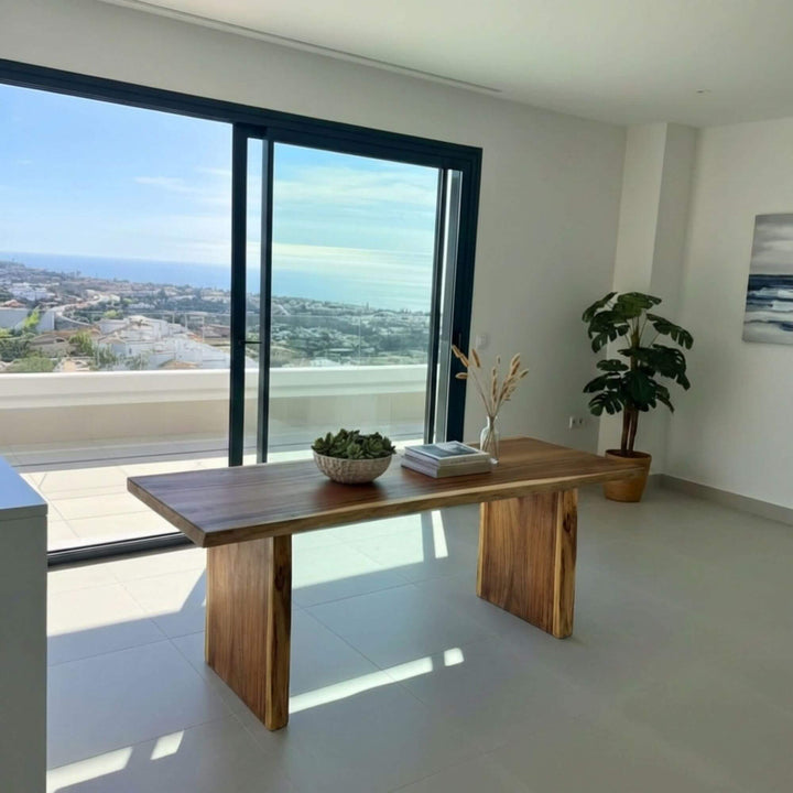 Suar wood dining table styled in a modern interior with ocean views.