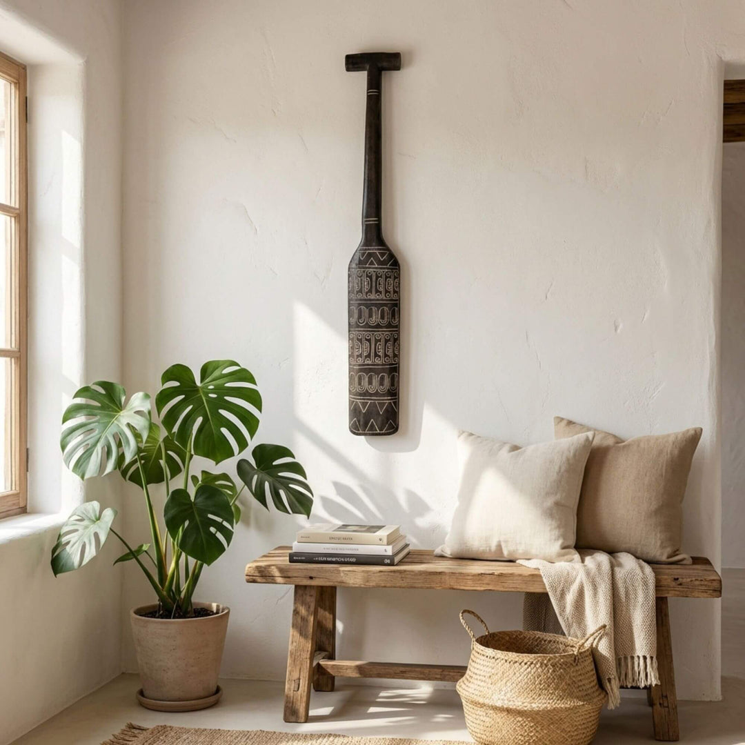 Styled interior setting featuring the Maui paddle mounted vertically on a wall above a wooden bench.