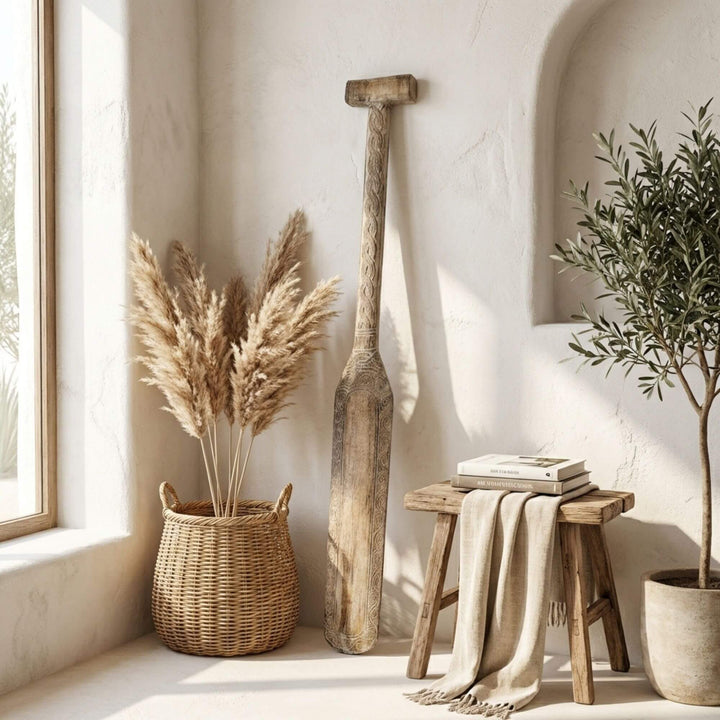 Styled interior setting featuring the Maui paddle displayed vertically near a bench with woven decor.