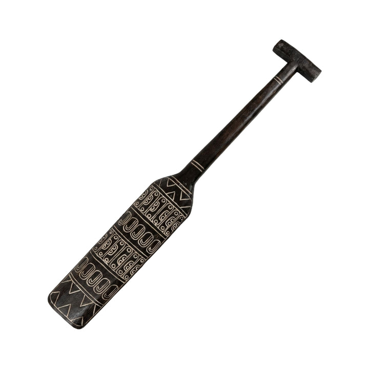Angled view highlighting the carved geometric patterns along the paddle blade.