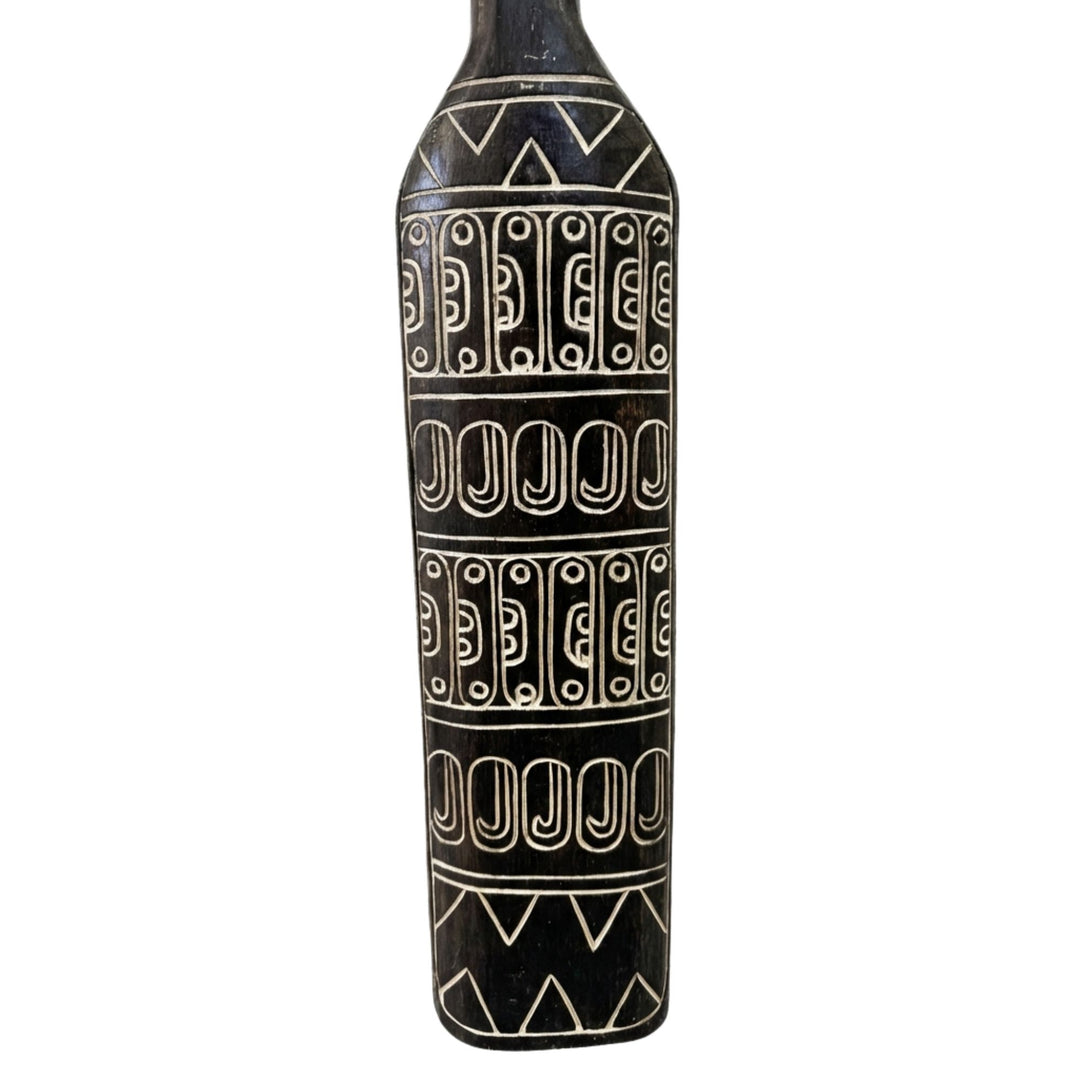 Close-up detail of the carved motifs and textured albasia wood surface.