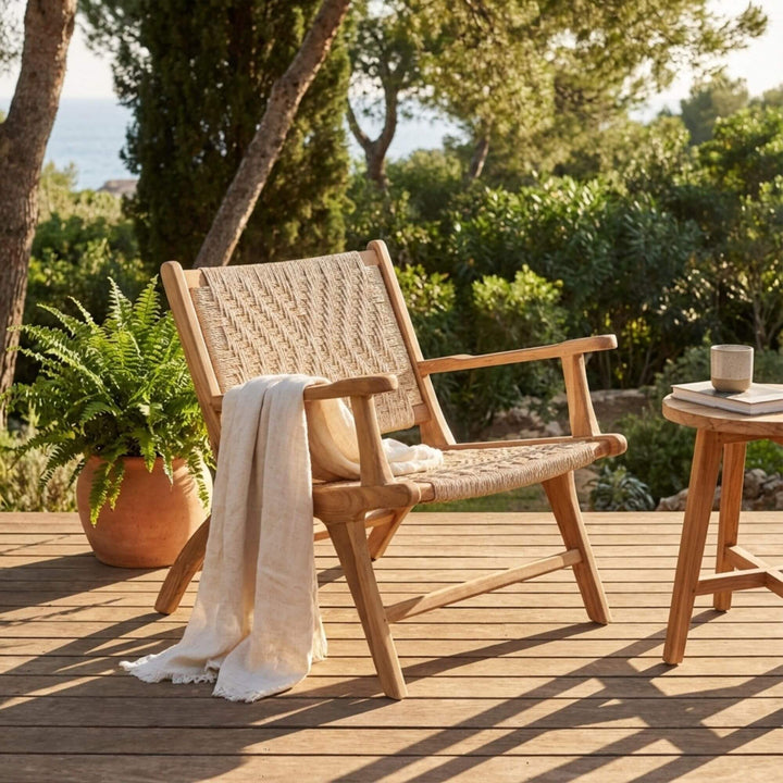 Styled outdoor terrace scene featuring the Milaidhoo armchair in a natural setting.