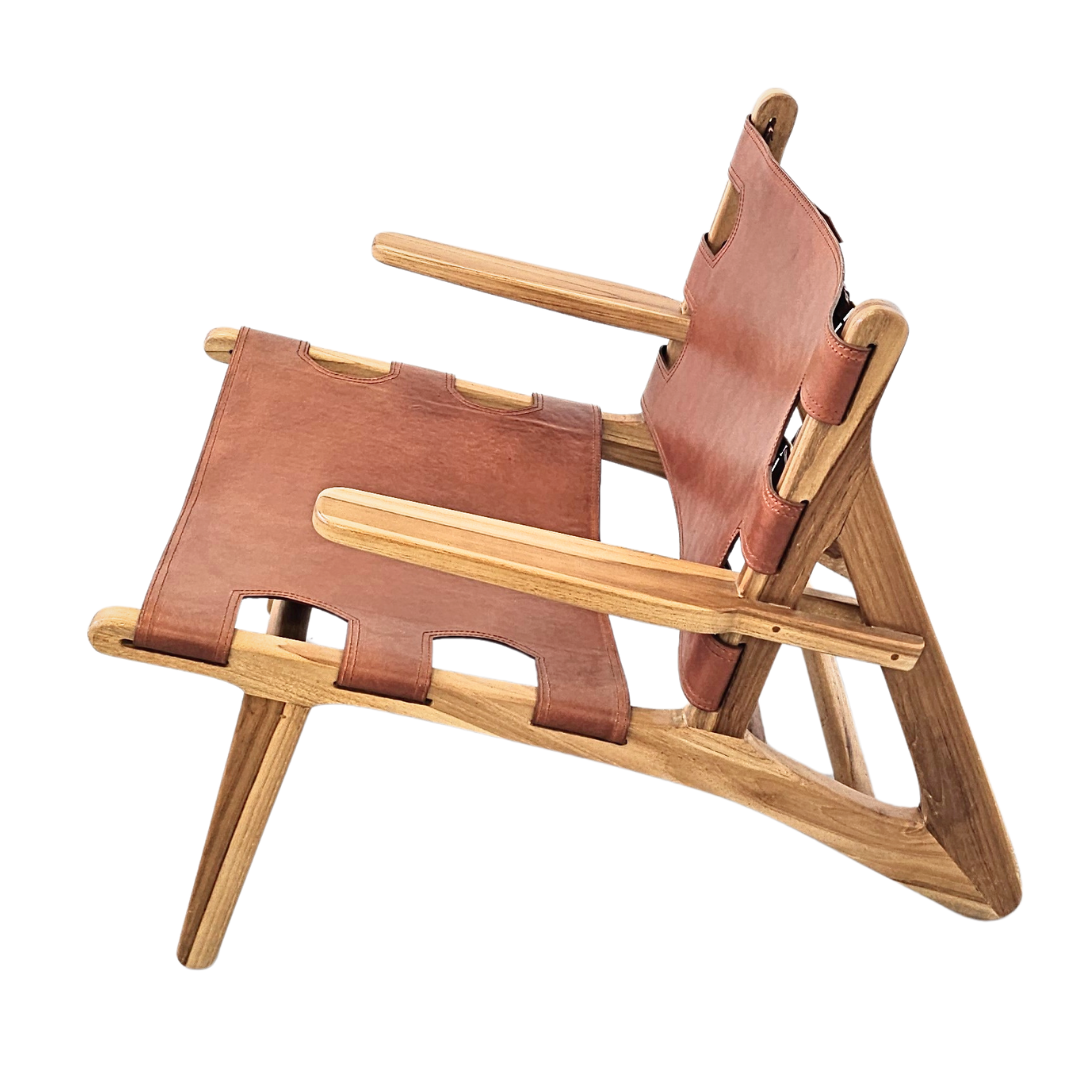 Side view of the Milaidhoo armchair highlighting the angled teak structure and leather detailing.