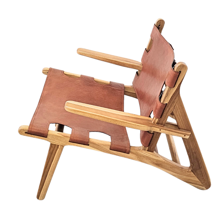 Side view of the Milaidhoo armchair highlighting the angled teak structure and leather detailing.