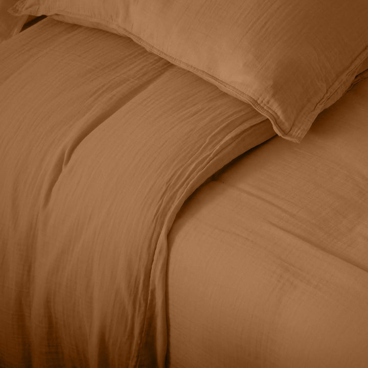 Detail of the Milos duvet cover showing its lightweight muslin weave and relaxed finish.