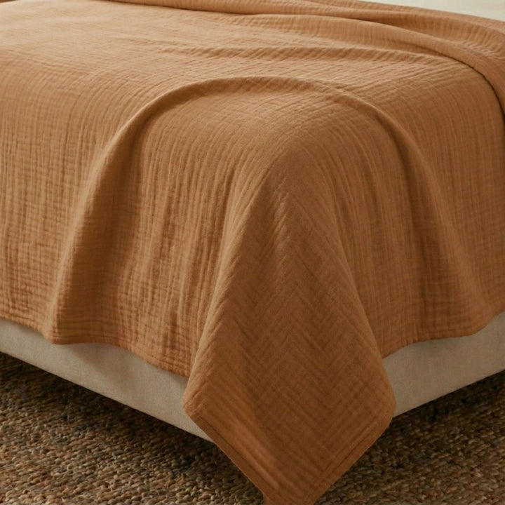 Close-up view of the Milos top sheet highlighting its muslin cotton texture and soft cognac finish.