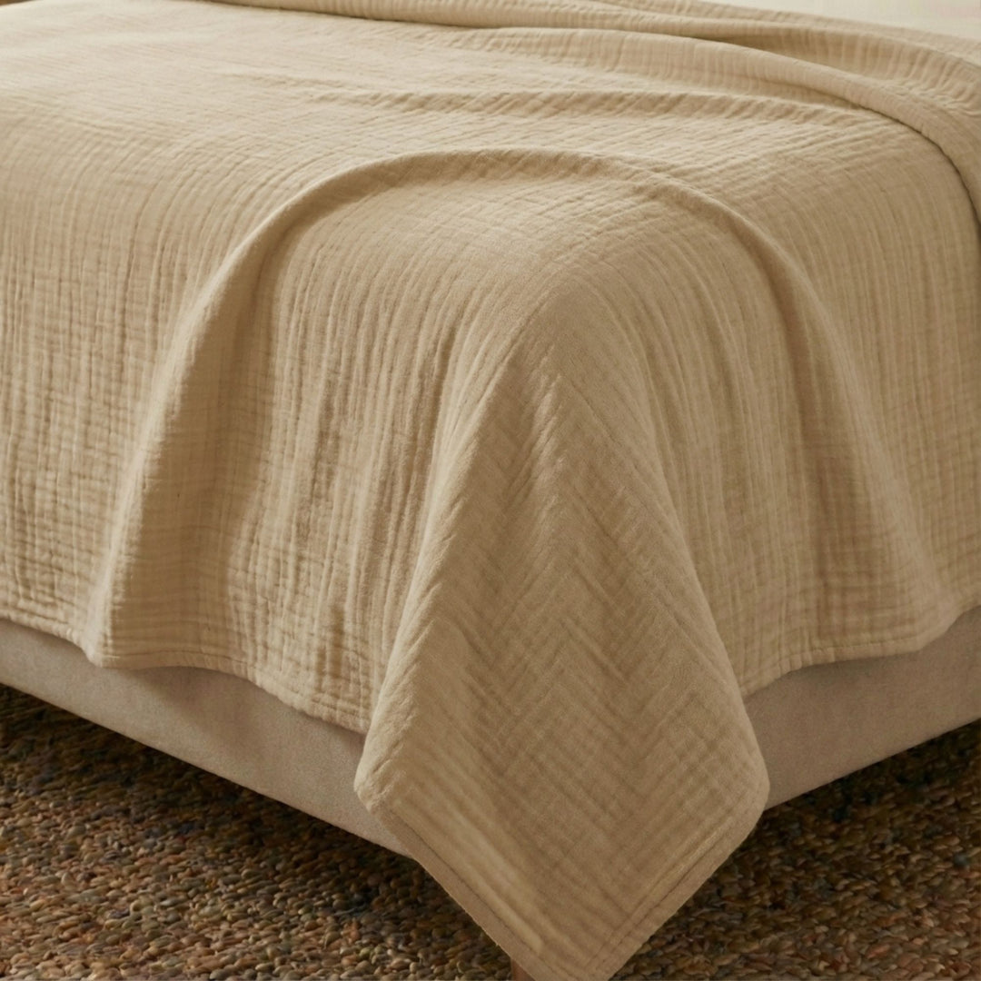 Close-up view of the Milos top sheet highlighting its muslin cotton texture and soft camel finish.