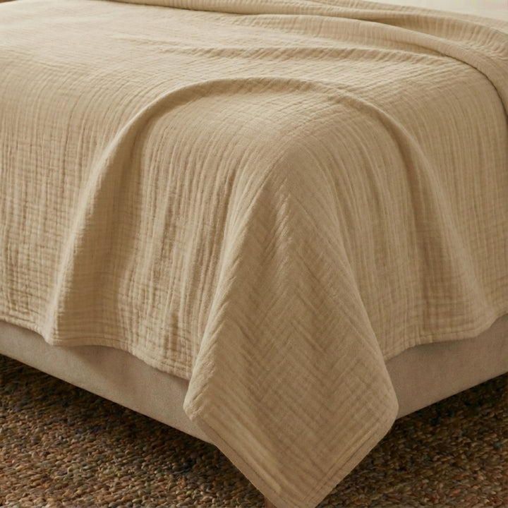 Close-up view of the Milos top sheet highlighting its muslin cotton texture and soft camel finish.