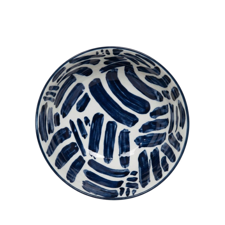 Top view of a Milos patterned bowl with bold blue brush strokes.