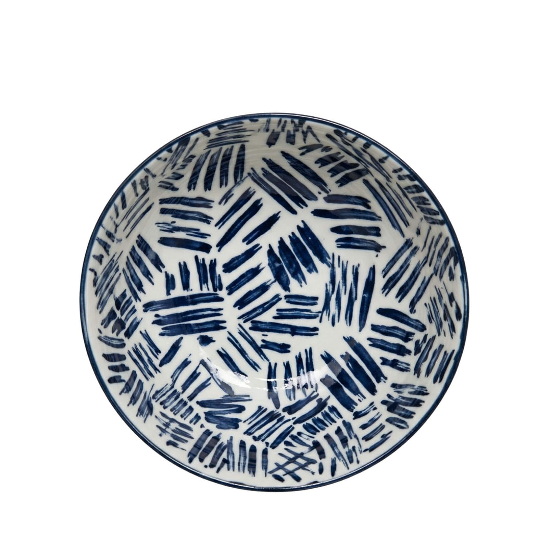 Top view of a Milos patterned bowl with bold blue brush strokes.
