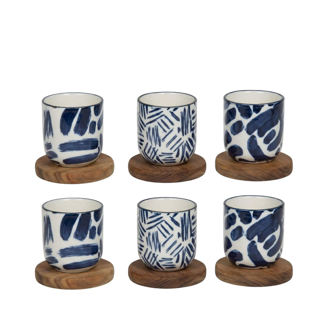 Set of Milos ceramic cups placed on wooden coasters.