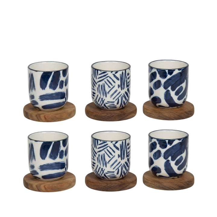 Set of Milos ceramic cups placed on wooden coasters.