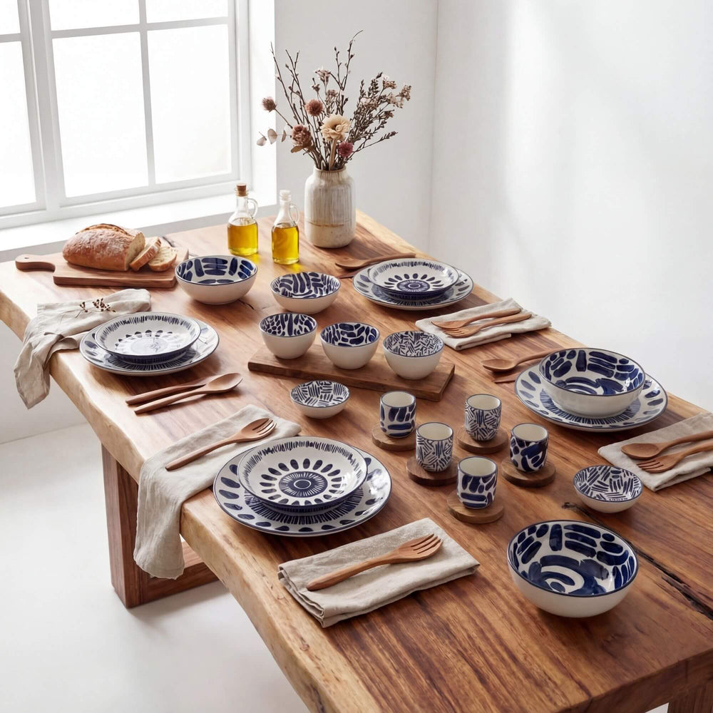 Styled dining table set with Milos ceramic tableware in white and blue tones.