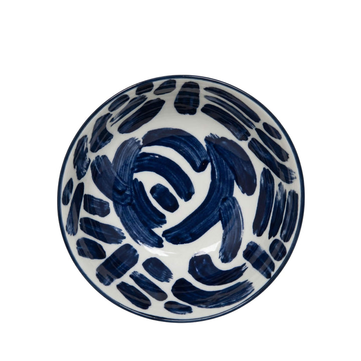 Top view of a Milos patterned bowl with bold blue brush strokes.
