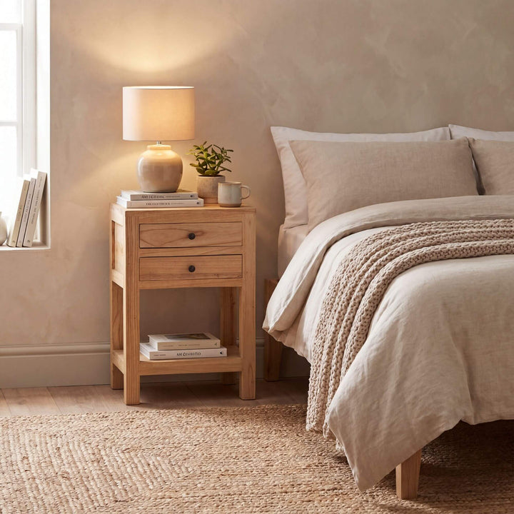 Styled bedroom setting featuring the mindi bedside table beside a bed in a warm natural interior.