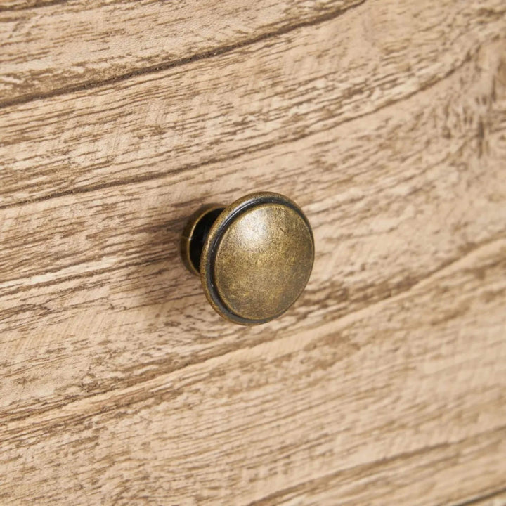 Close-up detail of the drawer front and round knob showing the natural wood texture.