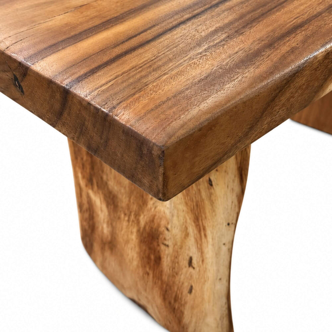 Close-up of the Minerva suar wood dining table highlighting the thick tabletop edge, natural grain, and wooden leg