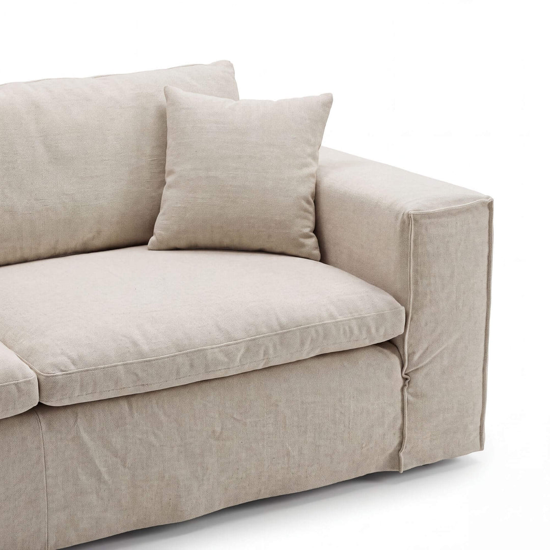 Close-up of the Modena sofa highlighting the relaxed linen upholstery, cushioned seat, and softly structured arm