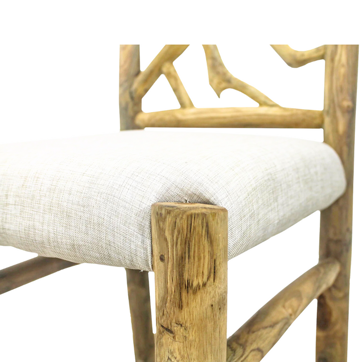 Close-up detail of rustic teak branches and light fabric cushion