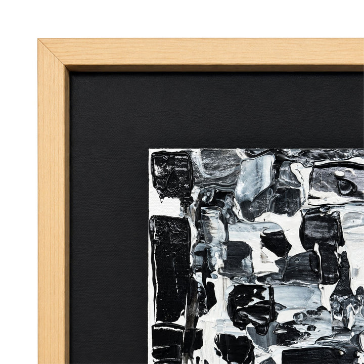 Close-up of the Monochrome painting highlighting the layered abstract texture, dark inner border, and natural wood frame