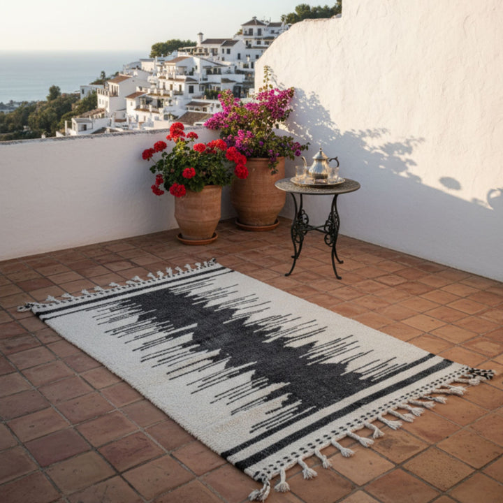 Outdoor terrace scene showcasing the Moroccan rug in a Mediterranean setting.