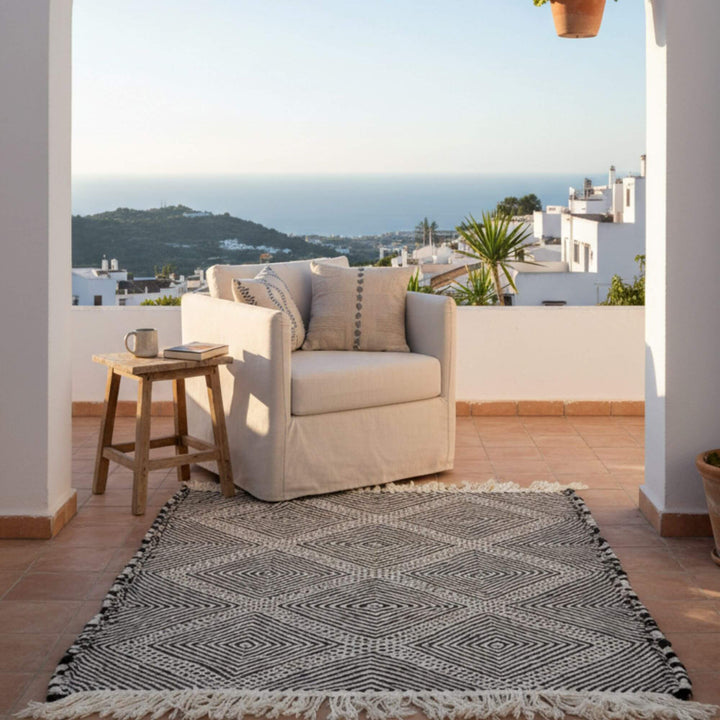Outdoor terrace setup featuring the Moroccan Rug beside a seating area.