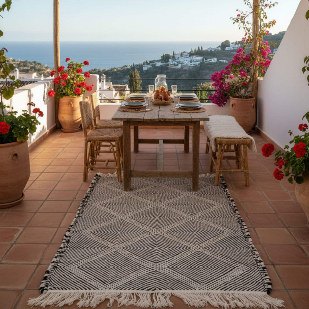 Patio view with the Moroccan Rug placed near a wooden table and plants.