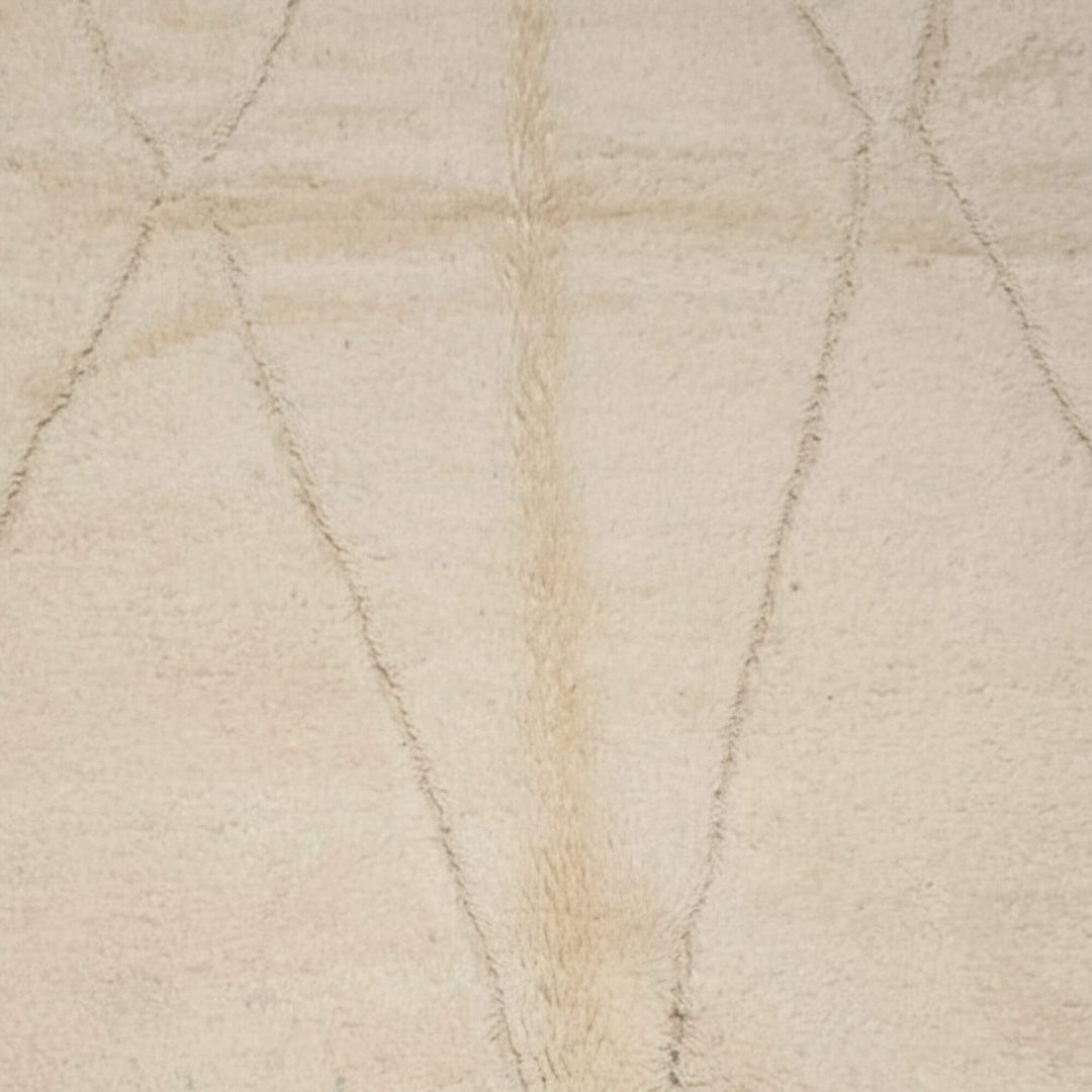 Close-up of the light cream wool texture showing the soft linear motif.