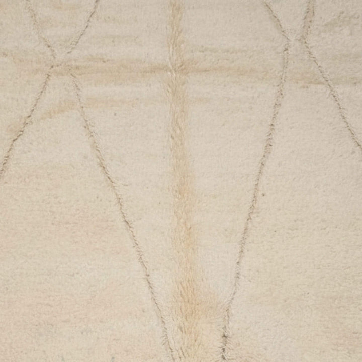 Close-up of the light cream wool texture showing the soft linear motif.