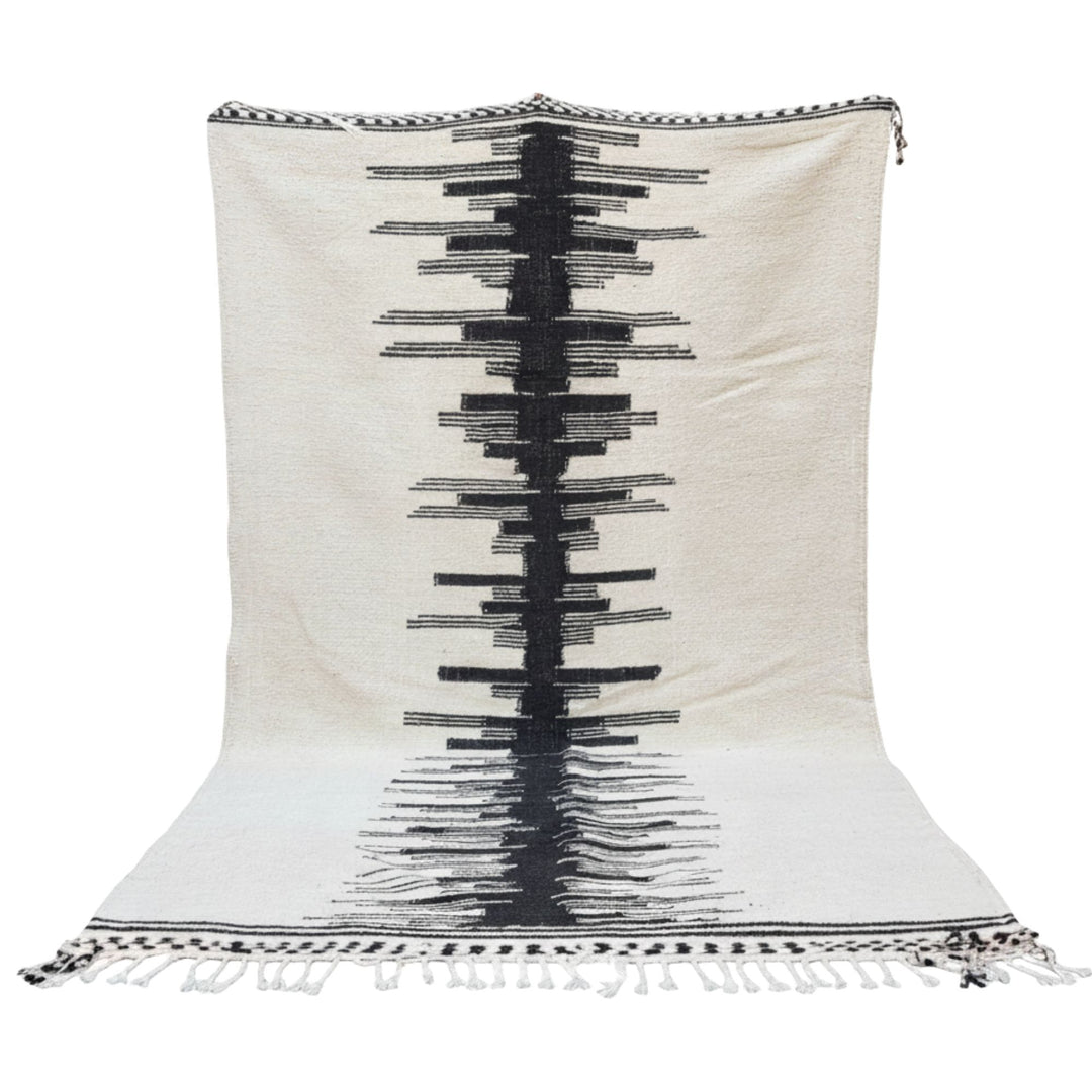 Front view of the large Moroccan wool rug with bold black geometric central pattern.