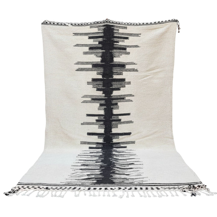 Front view of the large Moroccan wool rug with bold black geometric central pattern.