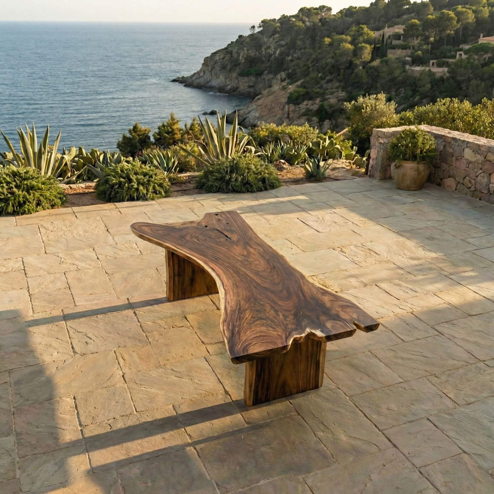 Outdoor dining setting featuring the Motu Nui table placed on a stone terrace overlooking the sea.
