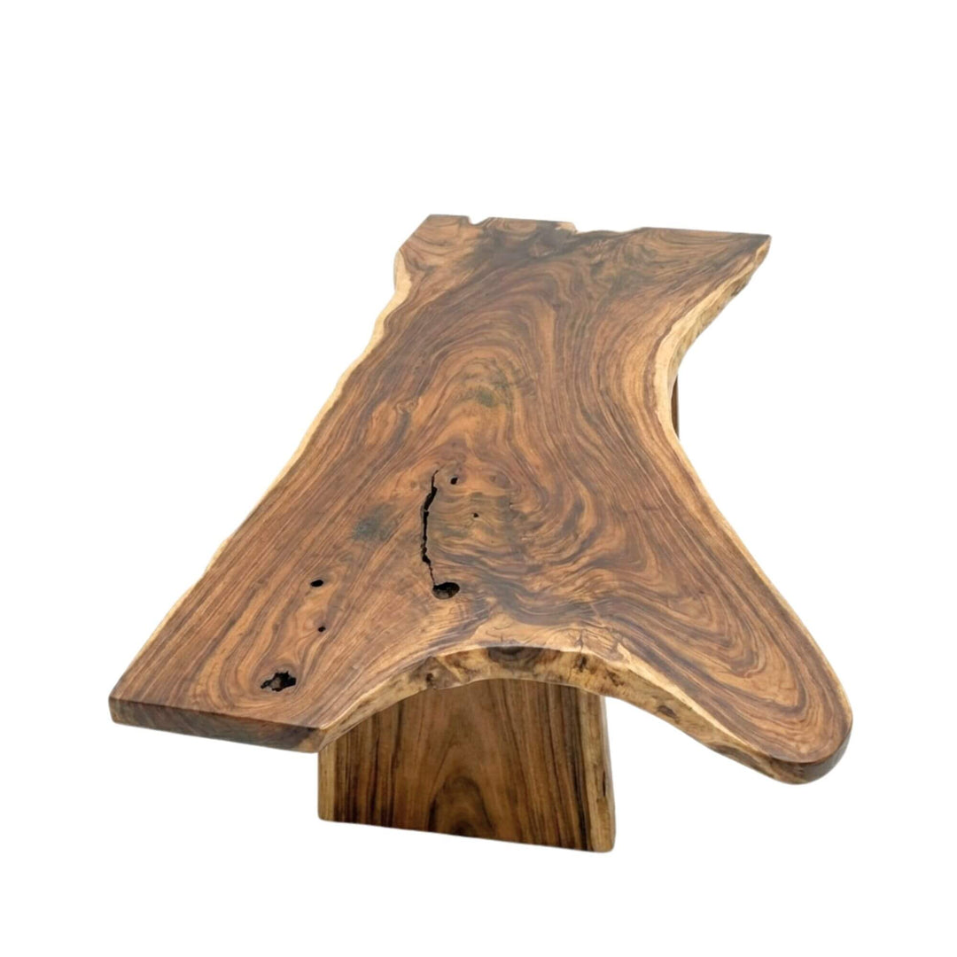 Angled view highlighting the organic contours and sculptural base of the suar wood table.