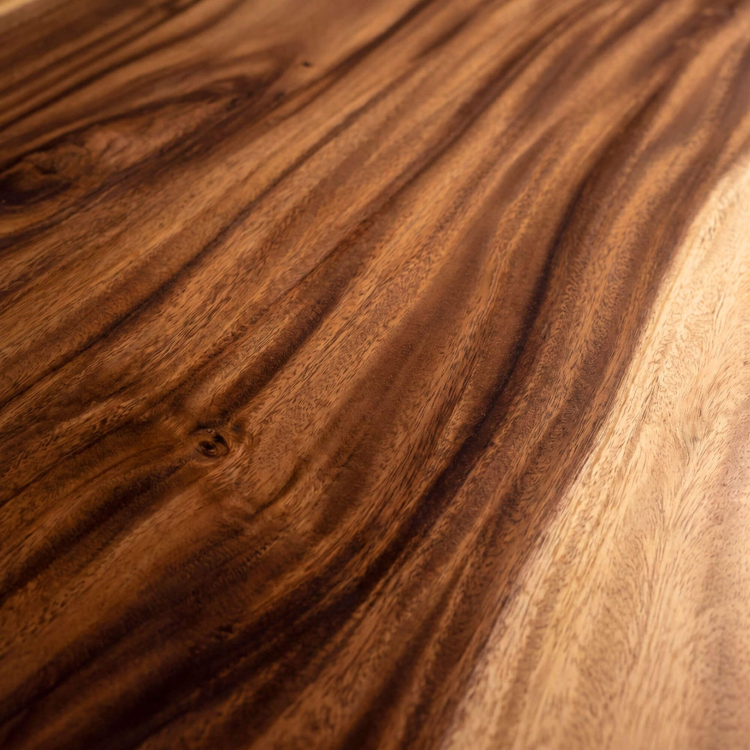 Close-up detail of the tabletop showing the flowing suar wood grain and warm tonal variation.