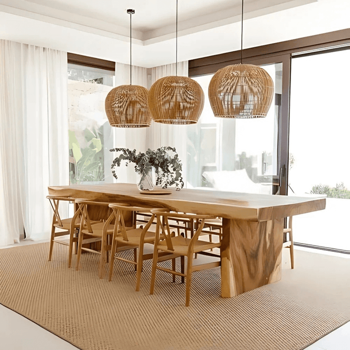 Dining area with a wooden table and chairs, featuring wicker pendant lights.