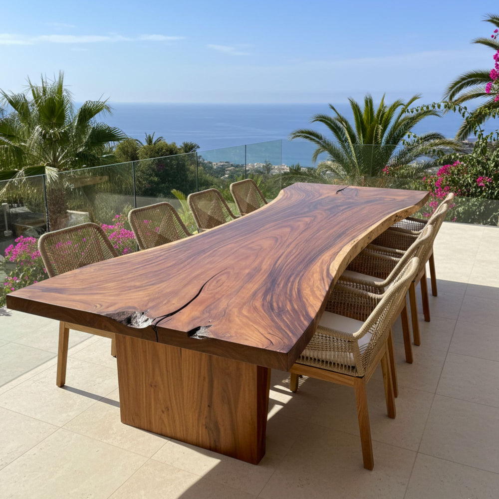 Front view of Motu Nui suar wood dining table with live-edge tabletop in an outdoor dining setting.