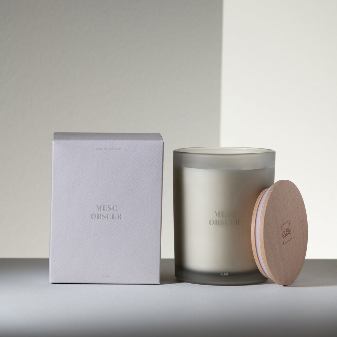 Musc Obscur candle displayed with packaging in a minimal, modern setting.