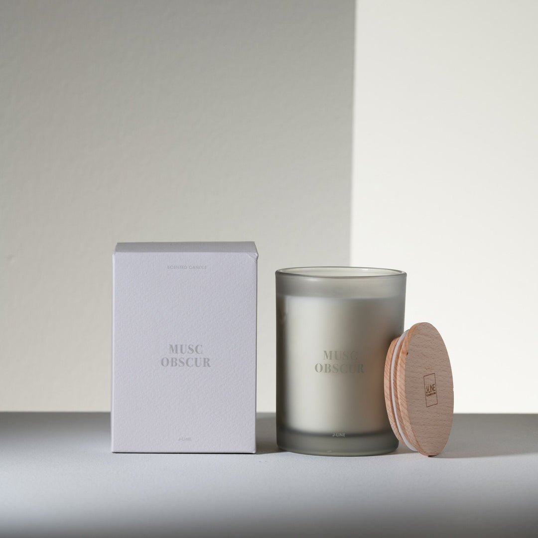 Musc Obscur candle displayed with packaging in a minimal, modern setting.